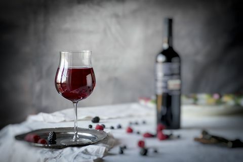 Raudonas vynas ir uogos ant stalo