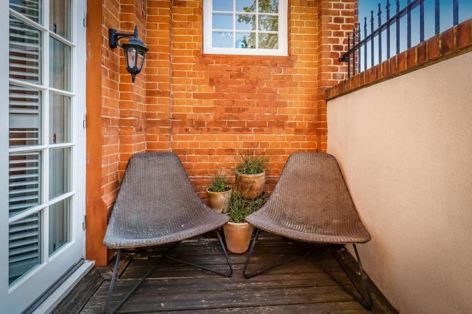 nedidelė vidinio kiemo terasa su dviem rudomis kėdėmis