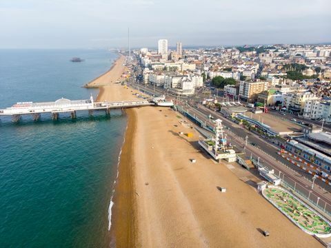 garsiosios Brighton prieplaukos ir vandenyno, esančio Anglijos pietinėje pakrantėje, kuri yra Brighton and Hove miesto dalis, oro nuotrauka, padaryta ryškią saulėtą dieną, parodant atrakcionų važiavimus