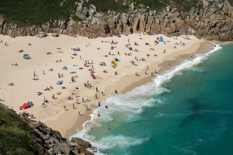 Lankytojai įsiurbia saulę Porthcurno paplūdimyje netoli Penzance 2018 m. Birželio 28 d.