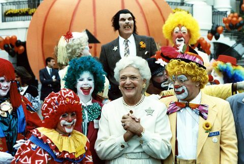 šioje nuotraukoje užfiksuota pirmoji ponia Barbara Bush besišypsanti pozuojanti su kostiumuotais atlikėjais, grupe klounų ir vienišo vilkolakio pietinėje baltojo namo teritorijoje kaip Helovino dalis šventė
