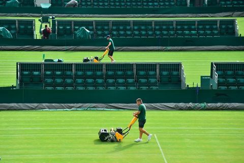 Antžeminis personalas pjauna žolę aikštelėje „The All England Lawn Tennis Club“ Vimbldone